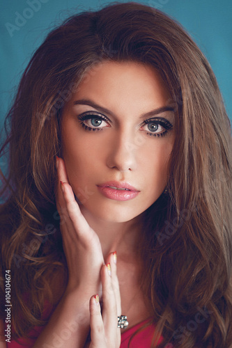 Fotografie a studio portrait of a young woman with long and wavy hair and b