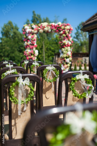 Brown chairs decorated for wedding ceremony