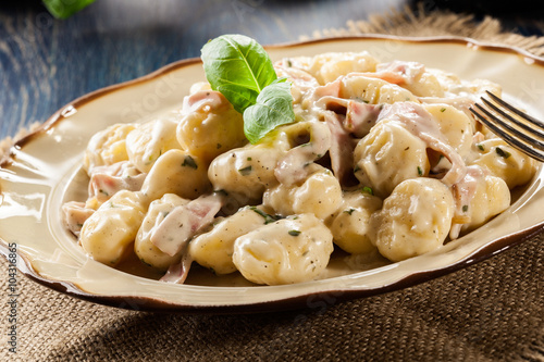 Potato gnocchi, Italian potato dumplings with cheese sauce, ham