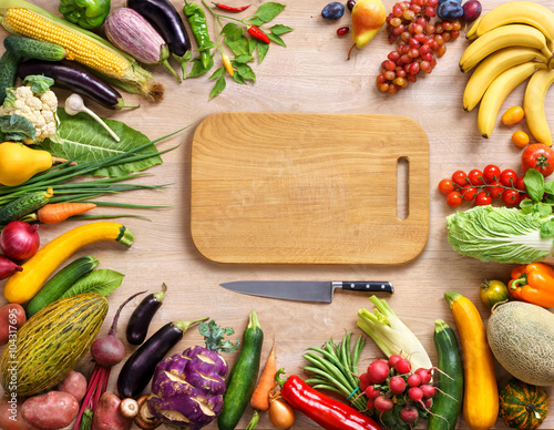 Healthy food background and Copy space / studio photography of wooden board surrounded by fresh vegetables on wooden table