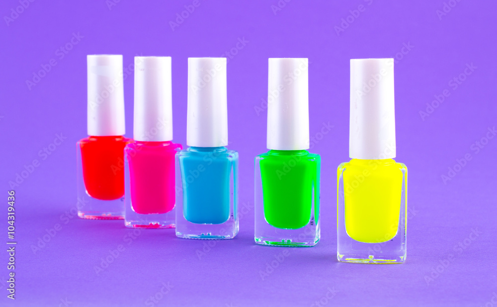 Nail polishes of different colors on a bright background. Bright nail polish colors pink, green, red, orange, blue to purple Nail polishes of different colors on a bright background. Bright nail polish colors pink, green, red, orange, blue to purple