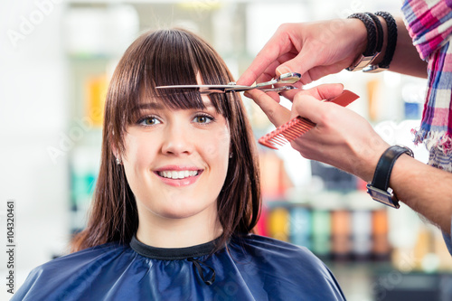 Friseur schneidet Frau die Haare im Friseursalon  photo