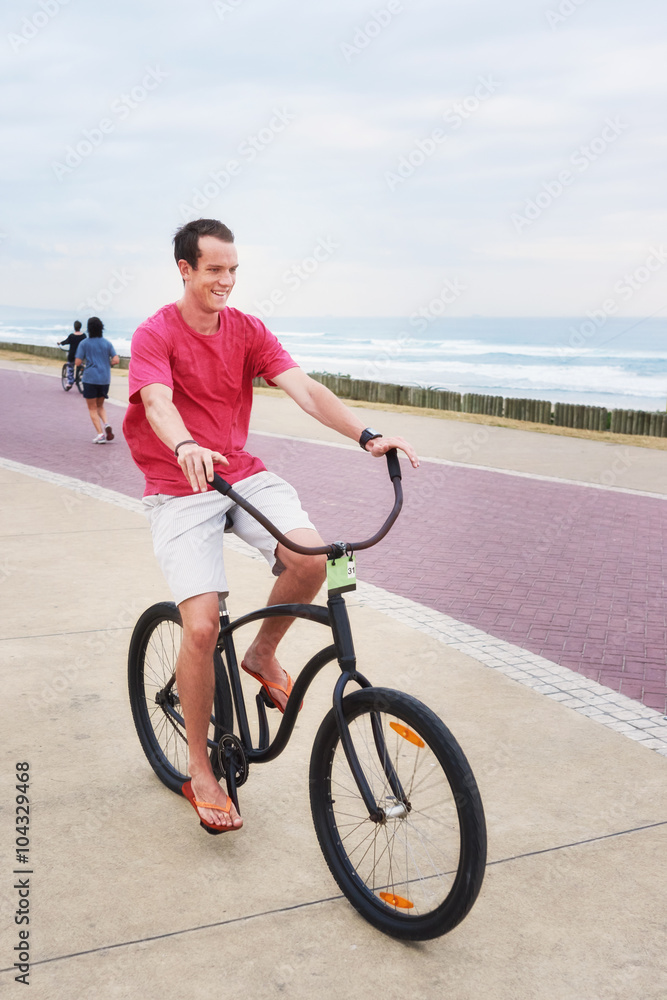 Young adult male riding his bicycle outdoors