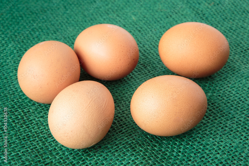 Fresh raw group of eggs put on green sack Fresh raw group of eggs put on green sack