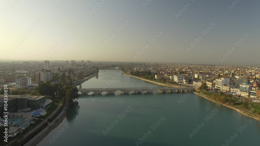 Aerial flyover the Ancient Stone Bridge on Seyhan River Adana Turkey in fantastic morning light Aerial flyover the Ancient Stone Bridge on Seyhan River Adana Turkey in fantastic morning light