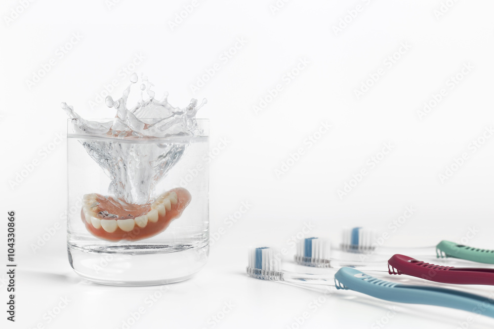 Dentures concept with glass, mask and toothbrush Dentures concept with glass, mask and toothbrush