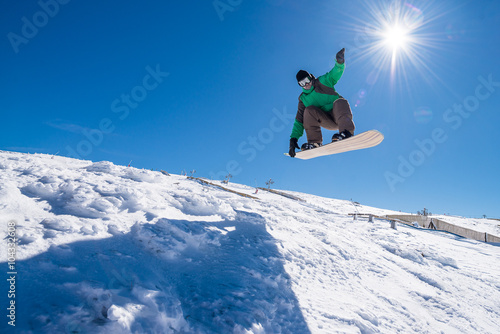 Foto Snowboarder jumping against blue sky