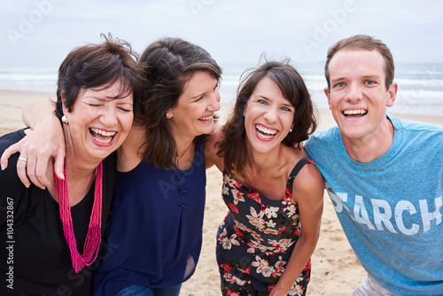 Family laughing and having fun on the beach together