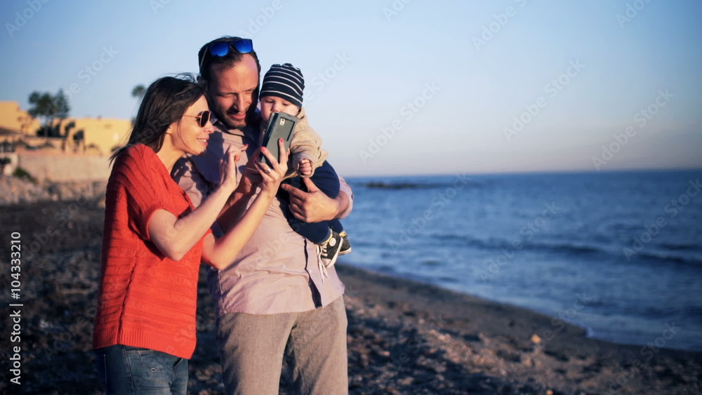 Happy family with small baby using smartphone on beach
Happy family with small baby using smartphone on beach