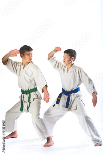 Karate boy in kimono fighting on a white background