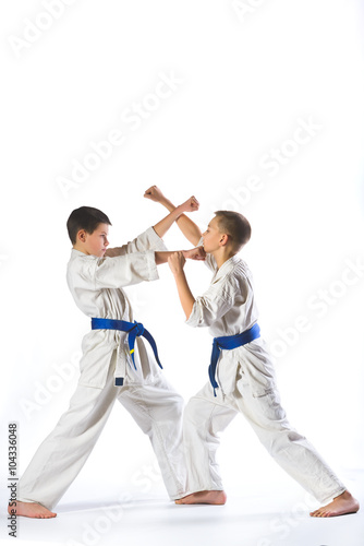 Karate boy in kimono fighting on a white background