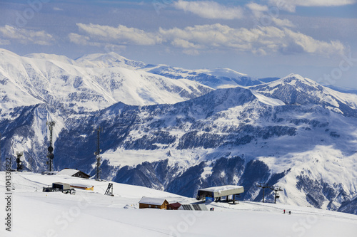 Panoramic view on ski station on snowy mountains background