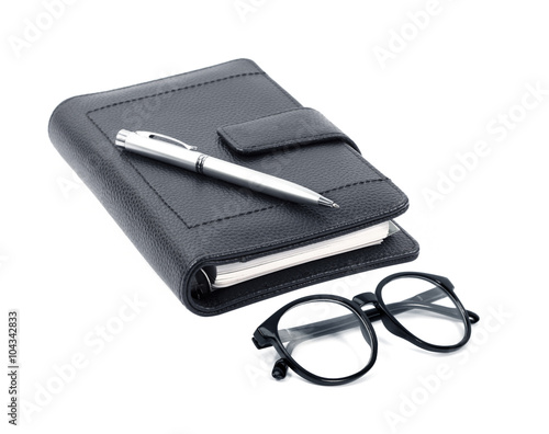 notebook with pen and glasses isolated on white