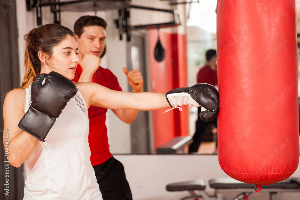 Cute girl boxing with a personal trainer