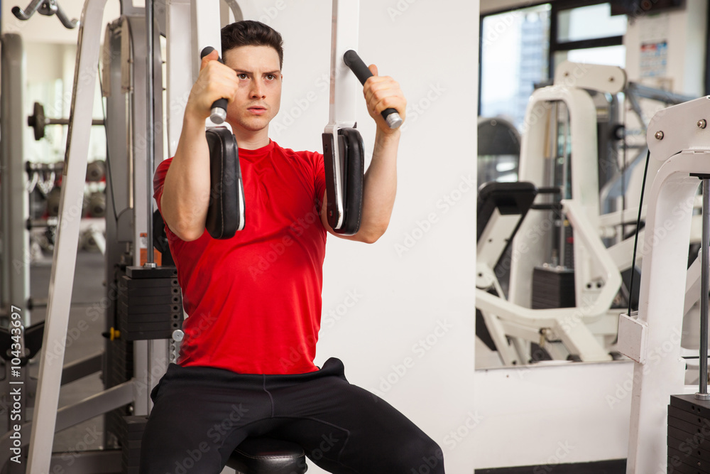 Fototapeta premium Young man exercising his chest muscles
