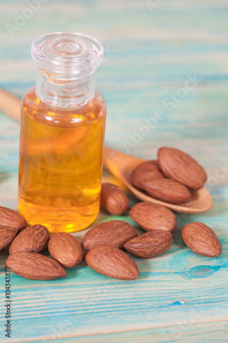 Almonds on wood and oil bottle