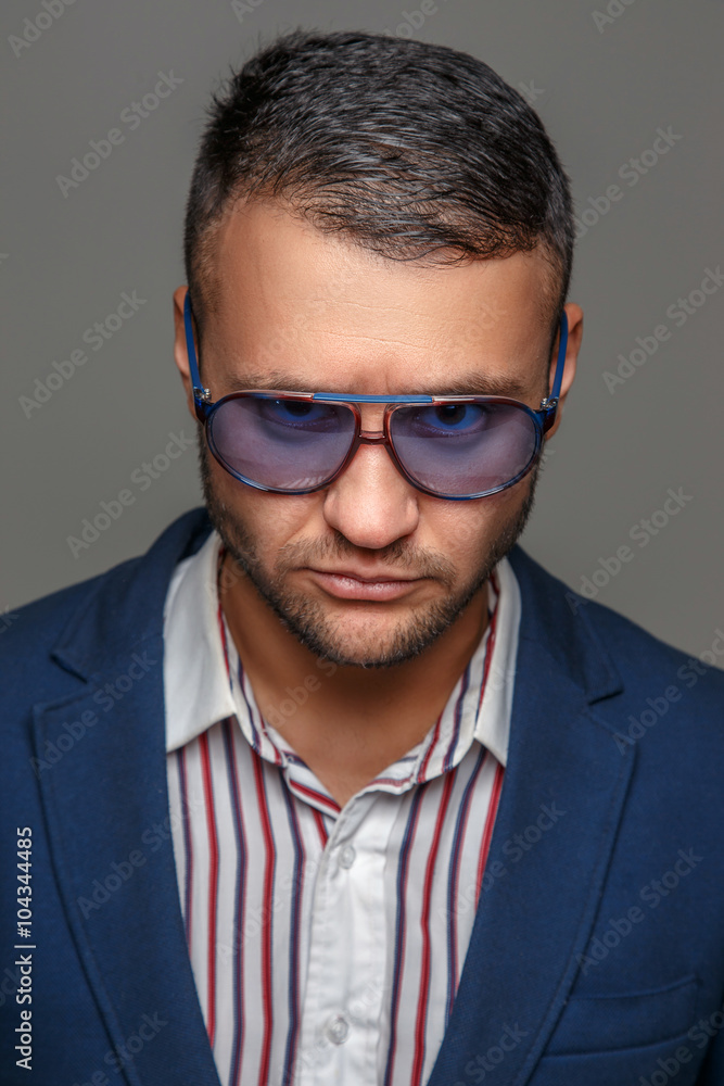A man in a blue suit and sunglasses. A man in a blue suit and sunglasses.