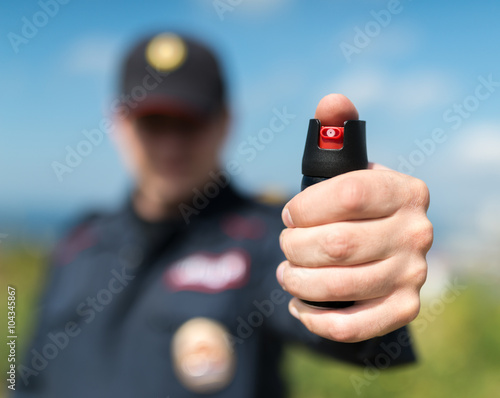 Fotografie Detail of a police officer holding pepper spray