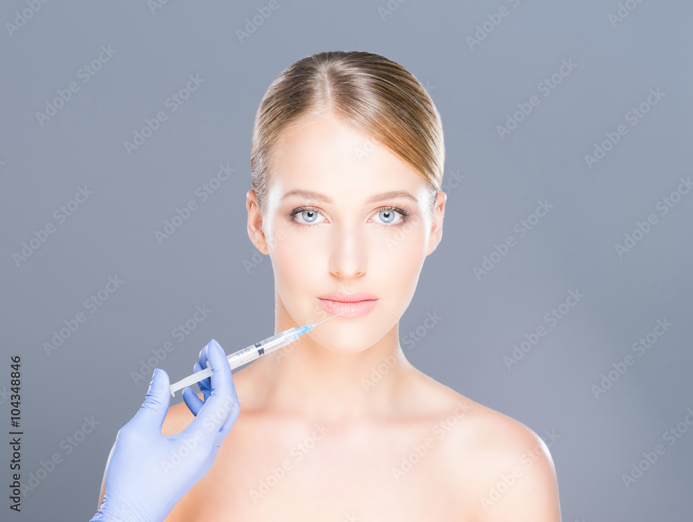 Doctor injecting botox in a beautiful face of a young woman. Plastic surgery concept. Doctor injecting botox in a beautiful face of a young woman. Plastic surgery concept.