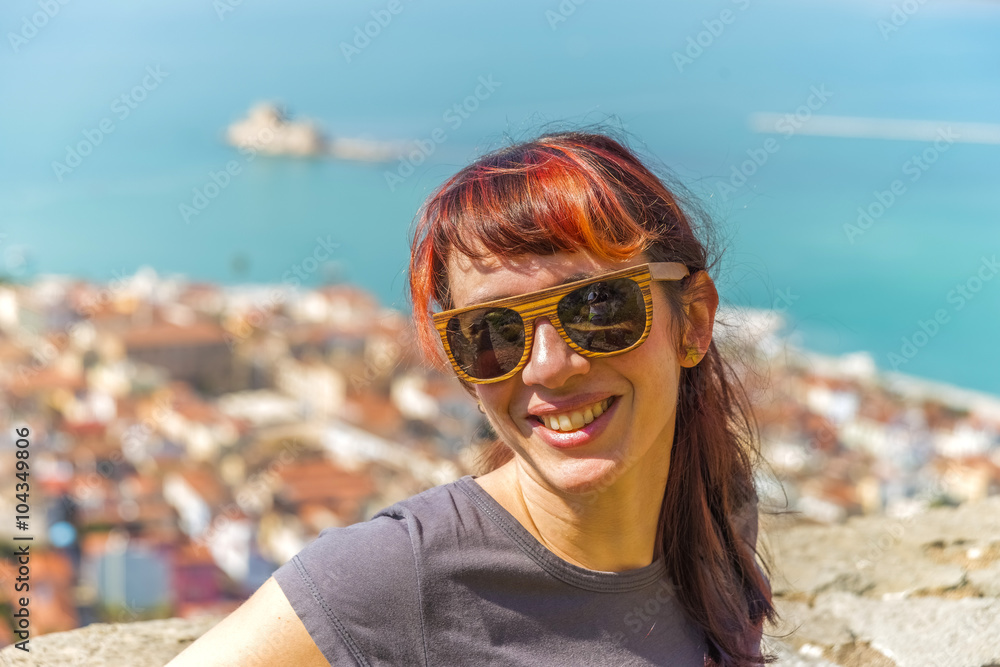 Smiling girl standing on top of a hill above the old town of Naf
