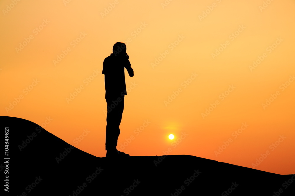 Silhouette picture of a man stand on the hill in the sunset scene
