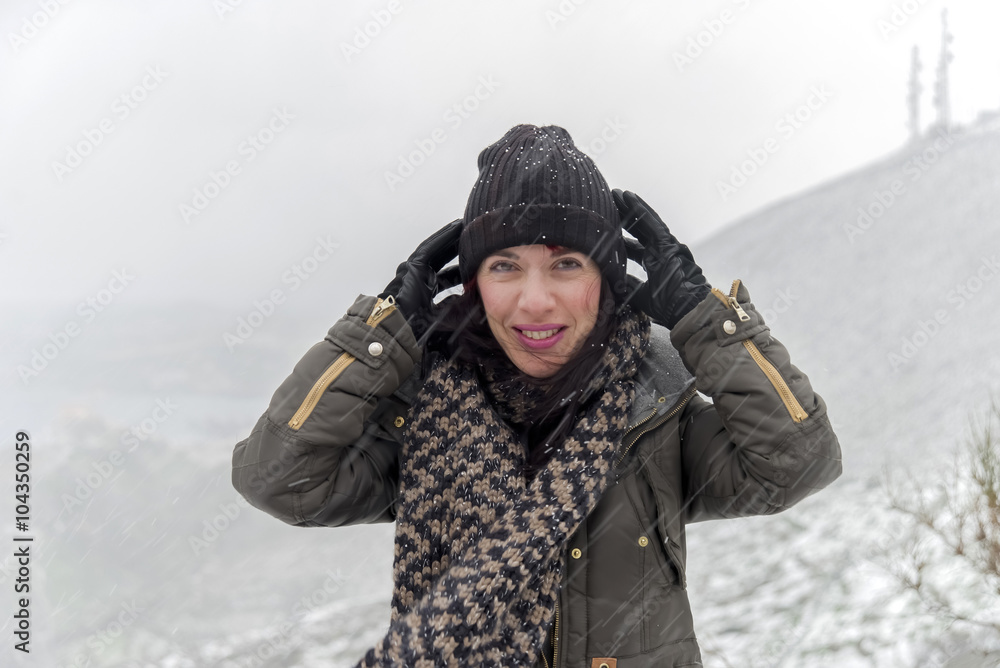 Beautiful young woman enjoying the snow on the mountains.