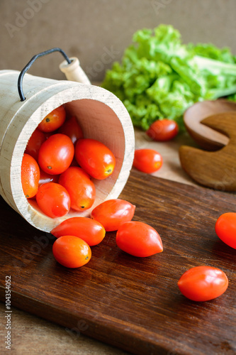 cherry tomatoes in small bucket on wooden table