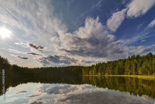 bright sun above forest lake