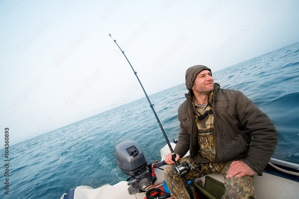 Fisherman catches a salmon in the sea