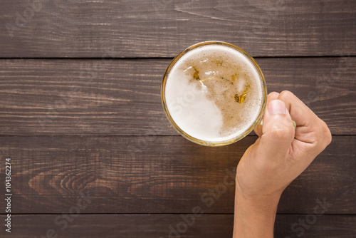 Hand is holding a glass of beer in the pub