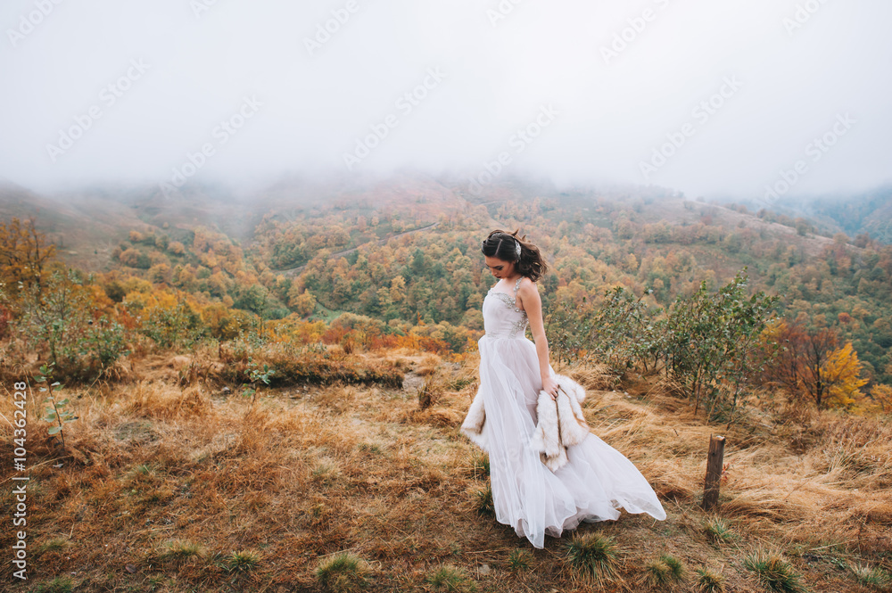 Beautiful bride posing in high mountain scenery Beautiful bride posing in high mountain scenery
