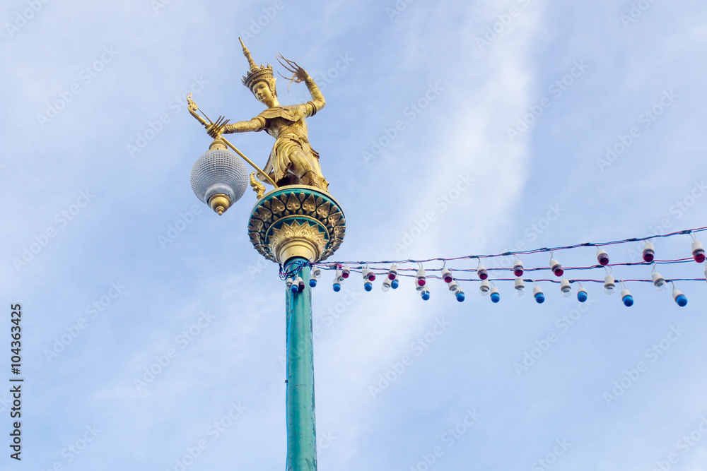 Golden statue of native thai art with street lamp