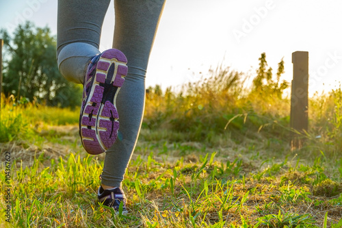 Woman running at sunset in a field