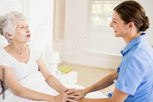 Nurse taking care of suffering senior patient 