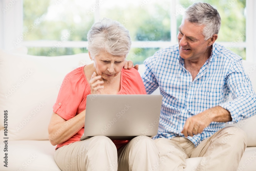 Smiling senior couple using laptop Smiling senior couple using laptop
