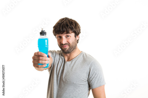 portrait of a handsome young man offering a sport drink bottle .
