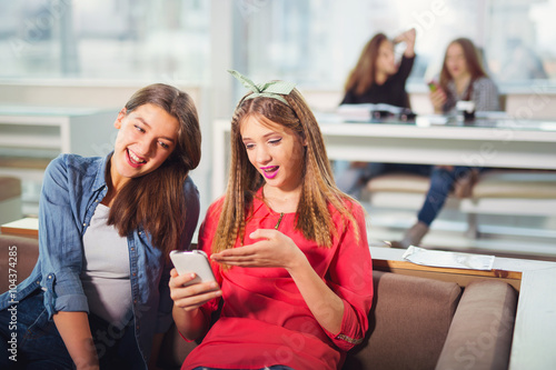 Portrait of four teenager girls sitting at the table in the cafe