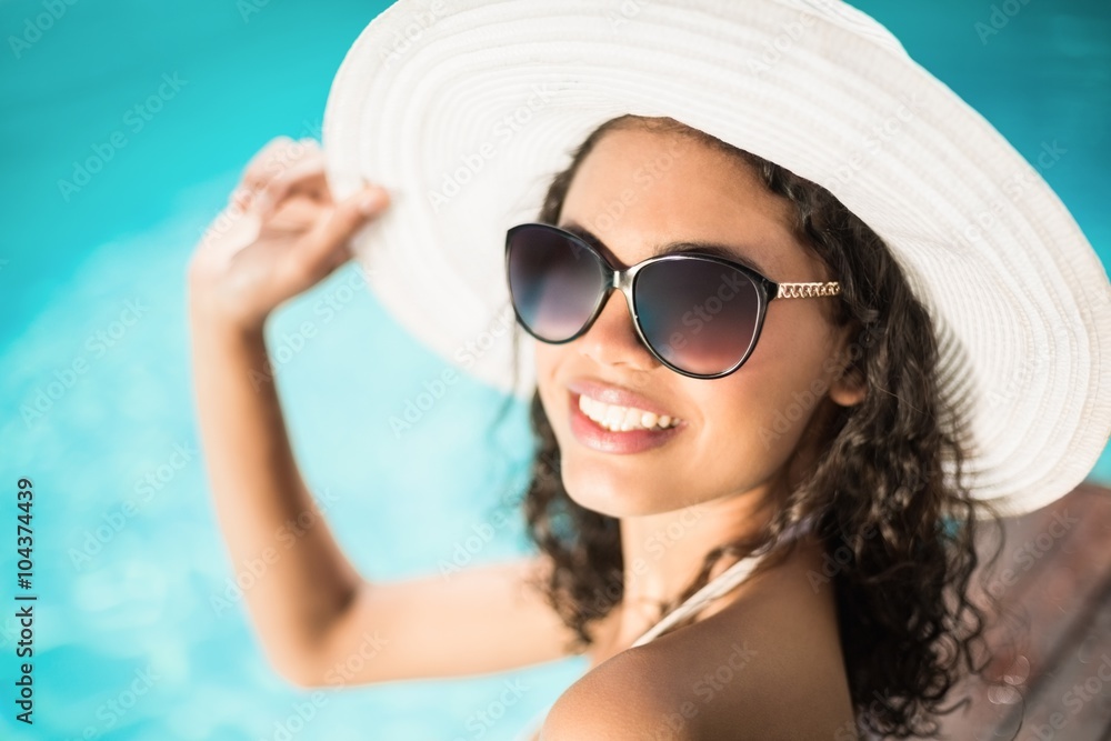Beautiful woman in sunglasses sitting by pool Beautiful woman in sunglasses sitting by pool