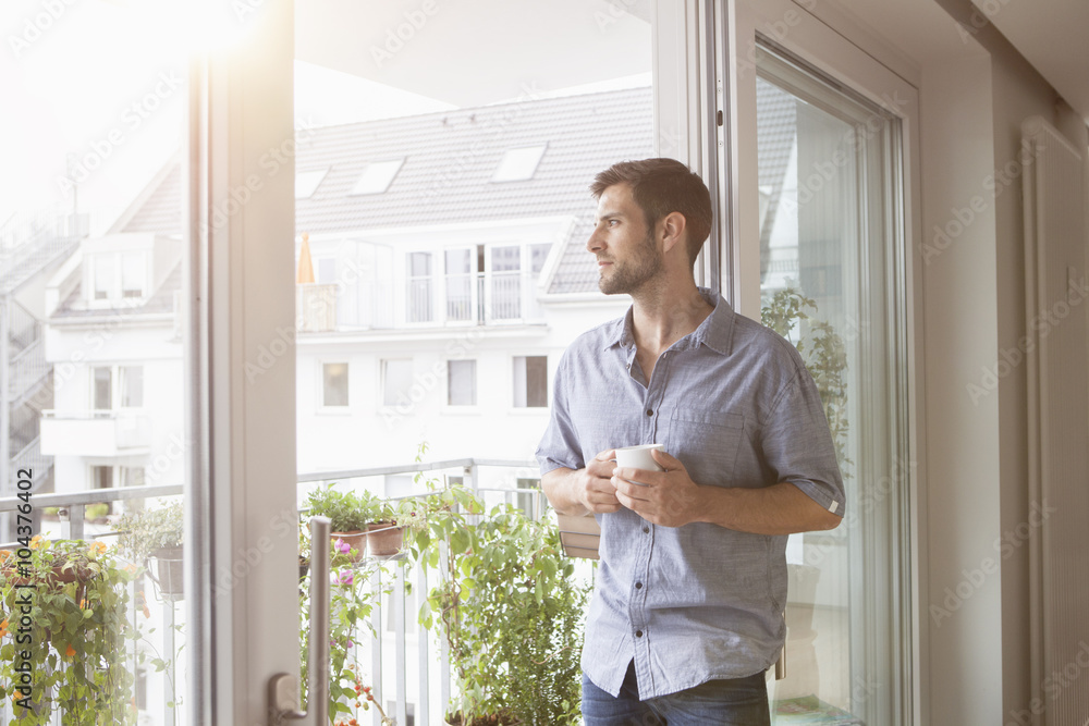 Serious man looking out of window Serious man looking out of window