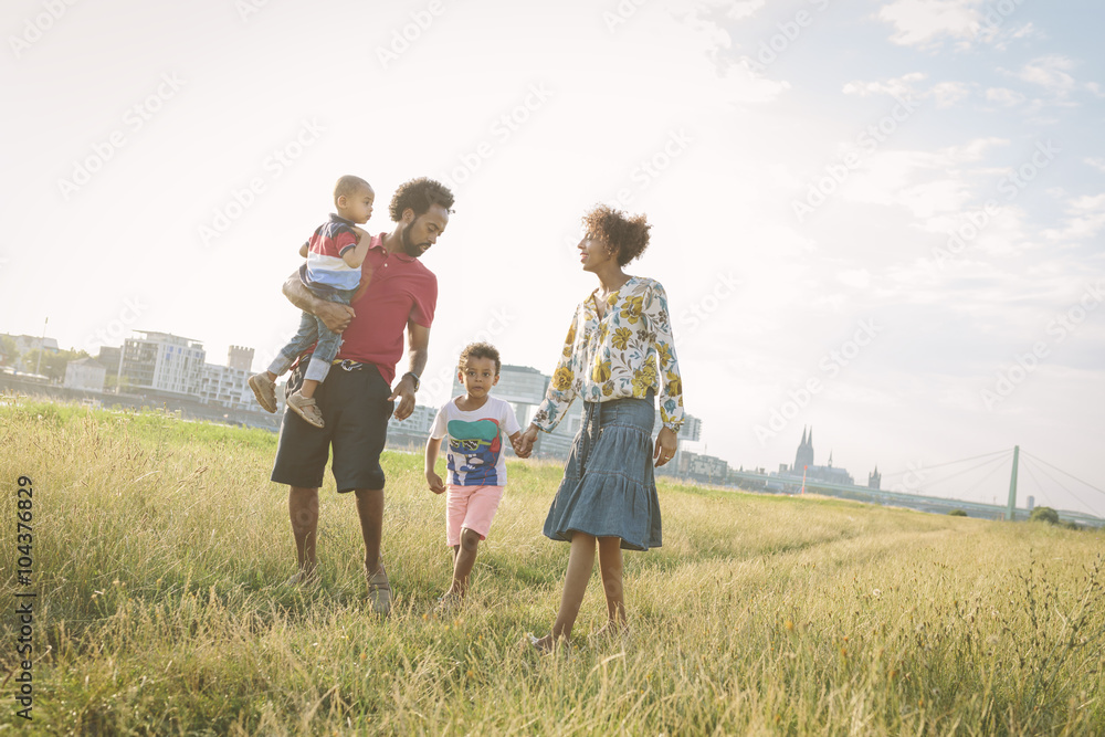Germany, Cologne, family of four walking in a field Germany, Cologne, family of four walking in a field