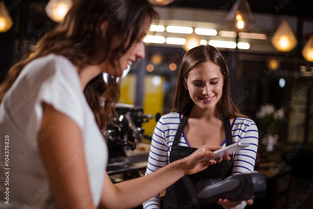Smiling woman paying with smartphone Smiling woman paying with smartphone