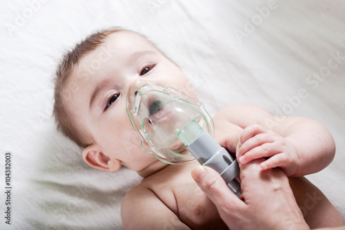 Doctor makes inhalation to a sick little baby.