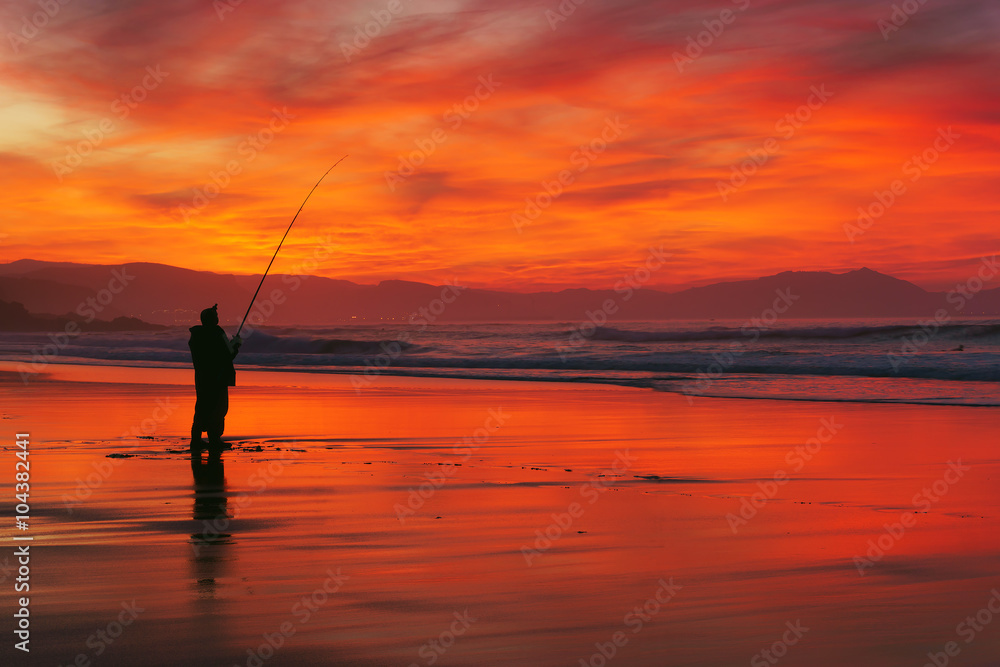 fisherman silhouette on beach at sunset fisherman silhouette on beach at sunset