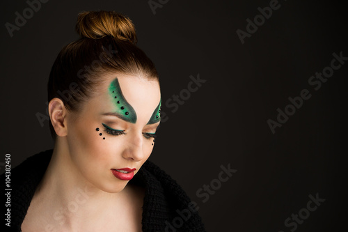 Creative make up of young woman in green tones.