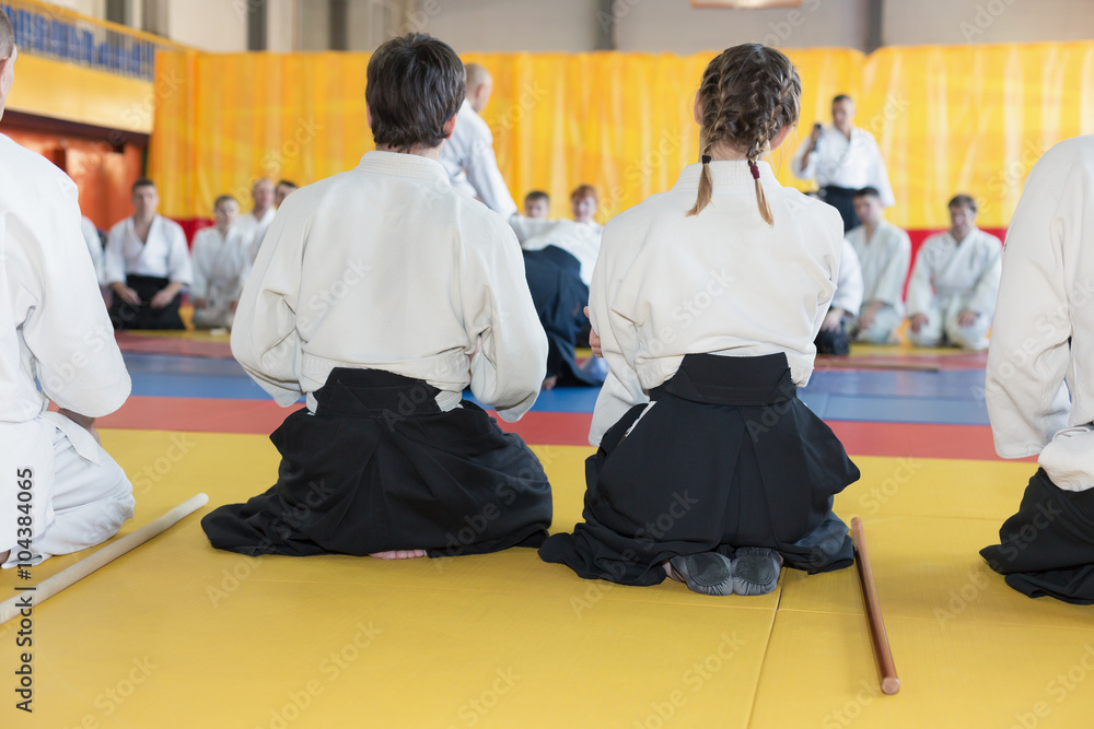 People in kimono and hakama sitting on tatami on martial arts training. Selective focus