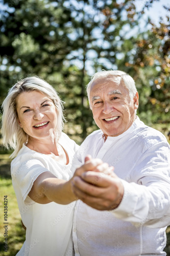 Happy elderly couple dancing outdoors Happy elderly couple dancing outdoors