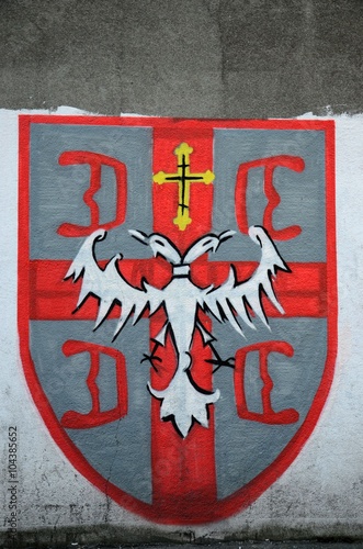Belgrade, Serbia - March 21, 2015: A painting of graffiti on a wall depicting a double headed eagle with Serb orthodox church cross on a shield. The shield is divided into four by a red cross.