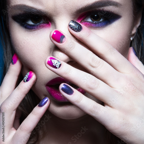 Beautiful girl with bright creative fashion makeup and colorful nail polish. Art beauty design.