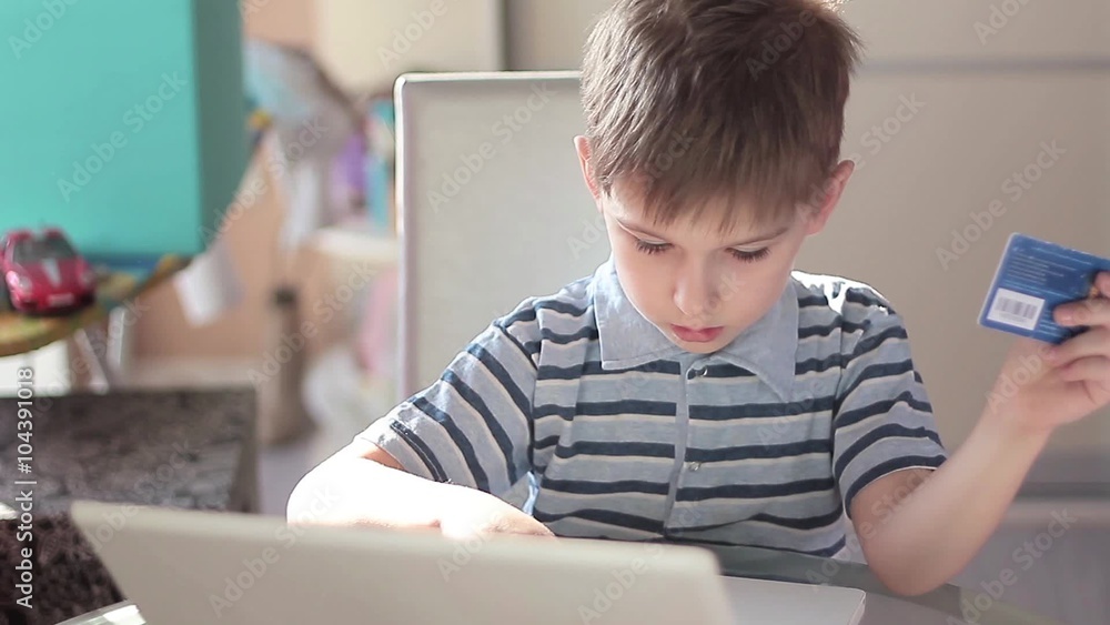 Cute little boy use laptop and credit card Cute little boy use laptop and credit card