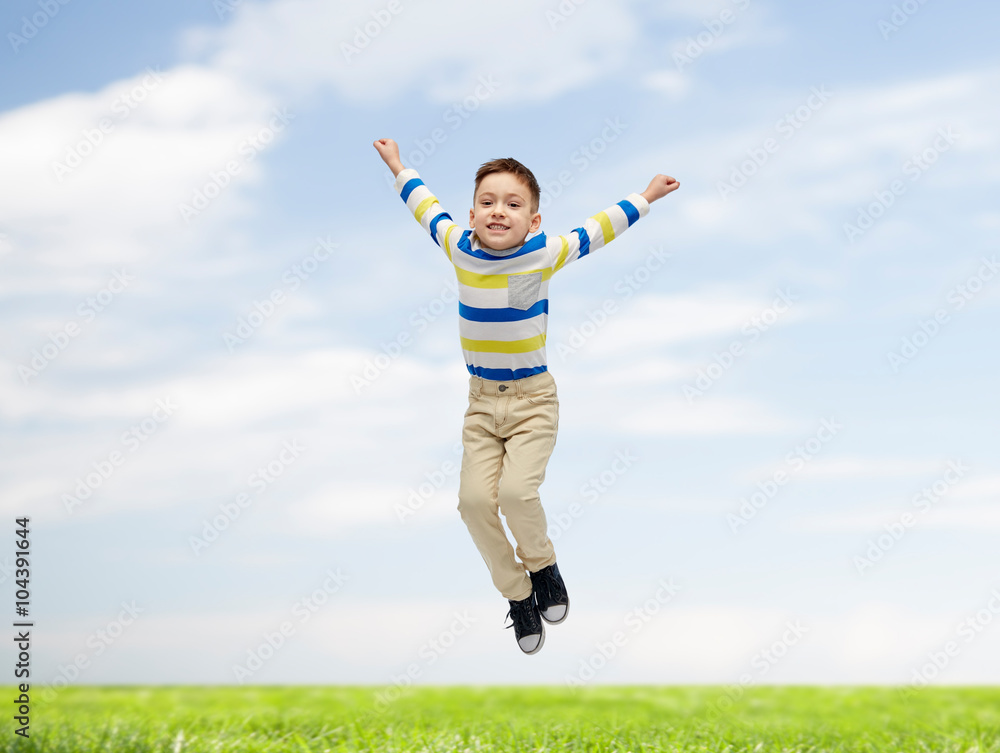happy little boy jumping over blue sky and grass happy little boy jumping over blue sky and grass